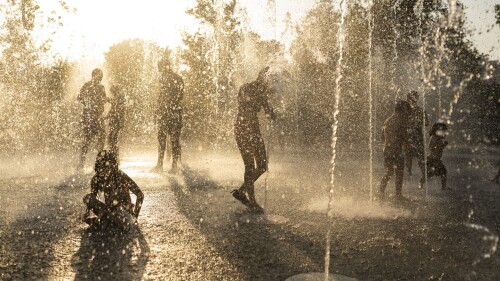 Children play with the water on a fountain during a heat wave, at Stavros Niarchos foundation Cultural Center in Athens, Friday, July 21, 2023. Heat in Greece is expected to grow worse during the weekend, approaching 44 Celsius (111 Fahrenheit) and the country will face one more heatwave episode by the end of July. (AP Photo/Petros Giannakouris)
