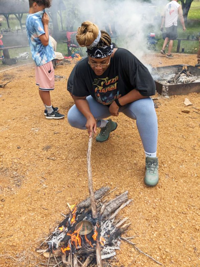 Char Adams tends to a fire in Allex, Texas, at Texas Survival School in May.