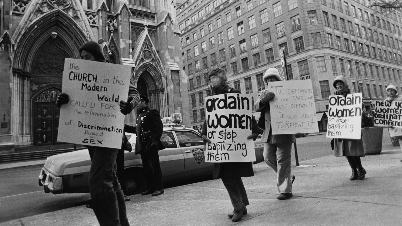 People at a pro women ordination demonstration holding placards which read 