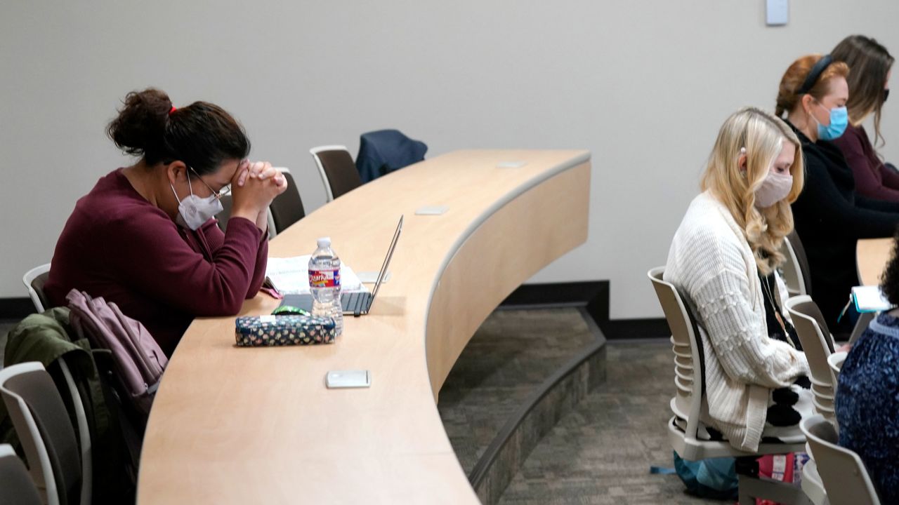 Christie Kim, left, and Emily Hesson, right, along with other students pray at the opening of a women's ministry class at the Southwestern Baptist Theological Seminary in Fort Worth, Texas, Thursday, Nov. 18, 2021. (AP Photo/LM Otero)