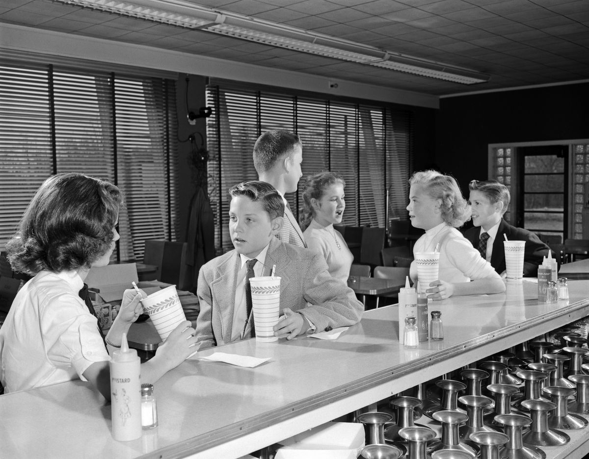 A bunch of hep teens in the 1950s hang out at a soda fountain