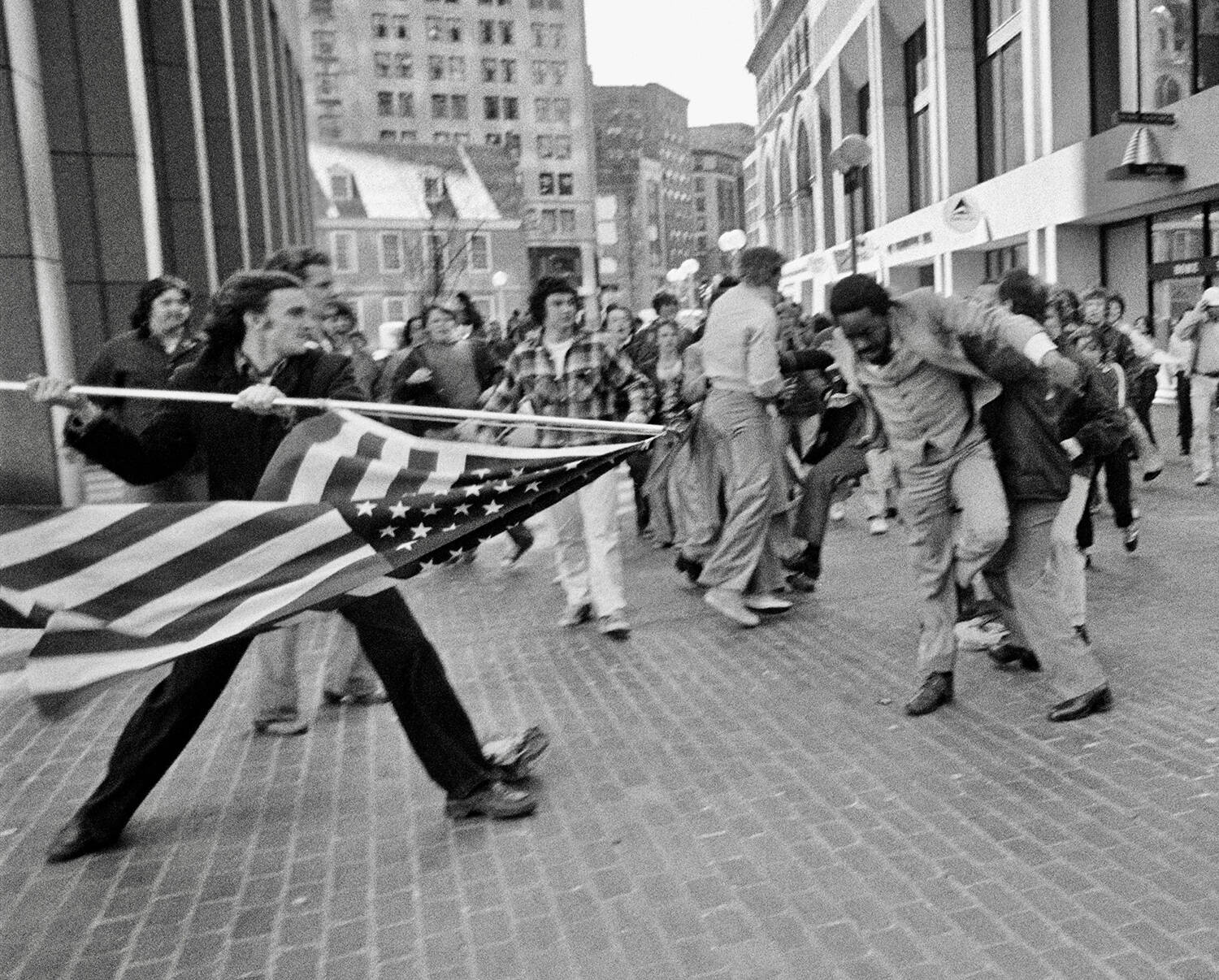In this photograph titled "The Soiling of Old Glory," Joseph Rakes assaults lawyer and civil rights activist Ted Landsmark with a flagpole bearing the American flag. (Stanley Forman)