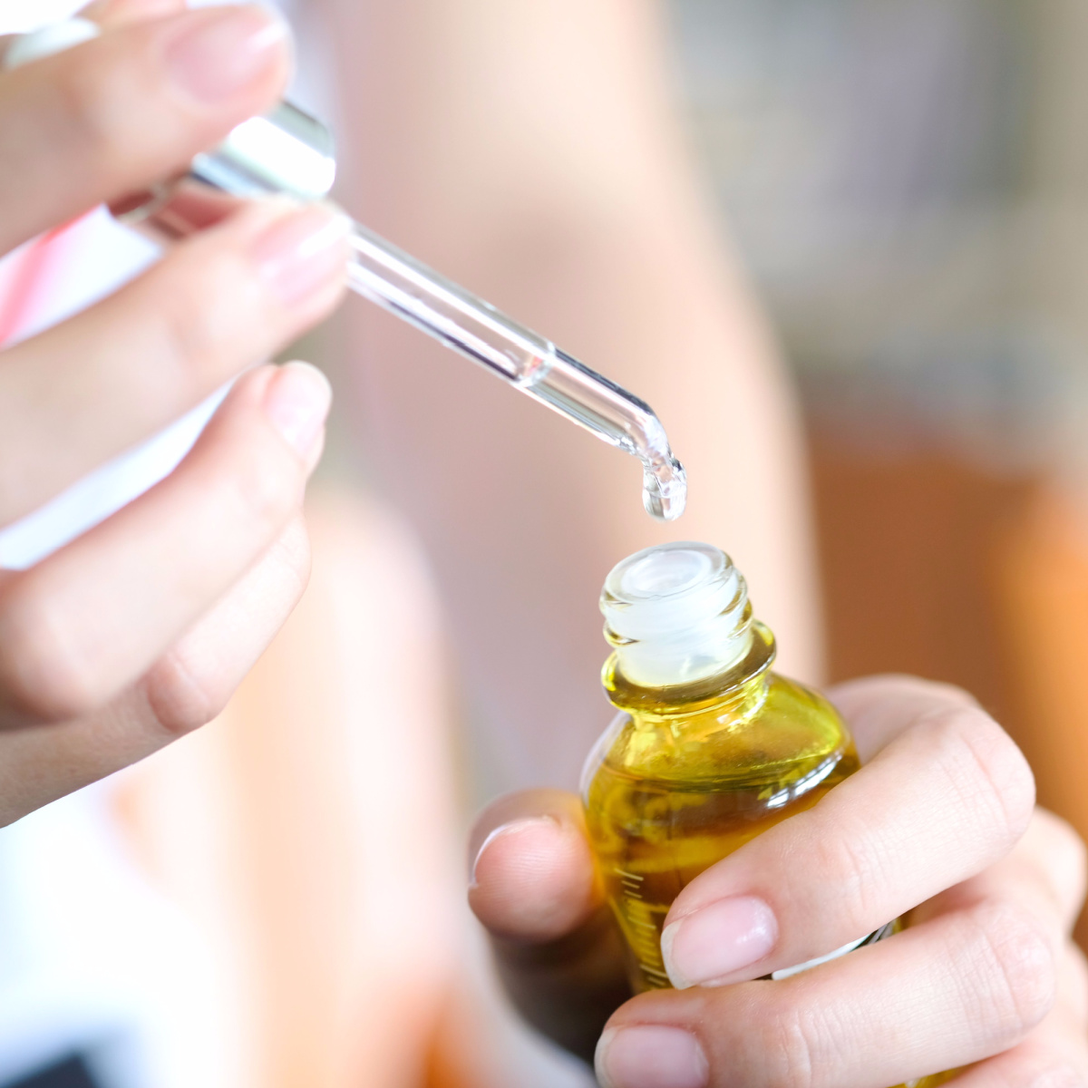 woman holding serum dropper product close up