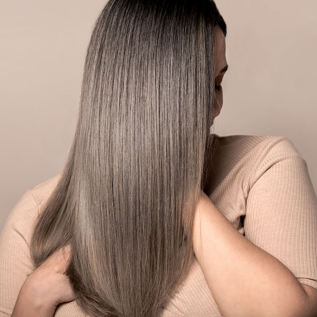 woman showing off thick shiny healthy brown hair straight