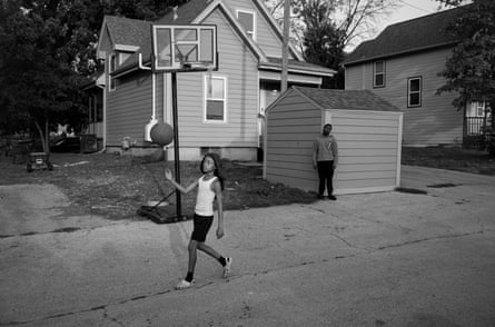 child plays with a basketball in front of a home