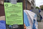 A posting is taped near a group of tents in downtown Portland, giving notice that the area will be swept, May 20, 2022.