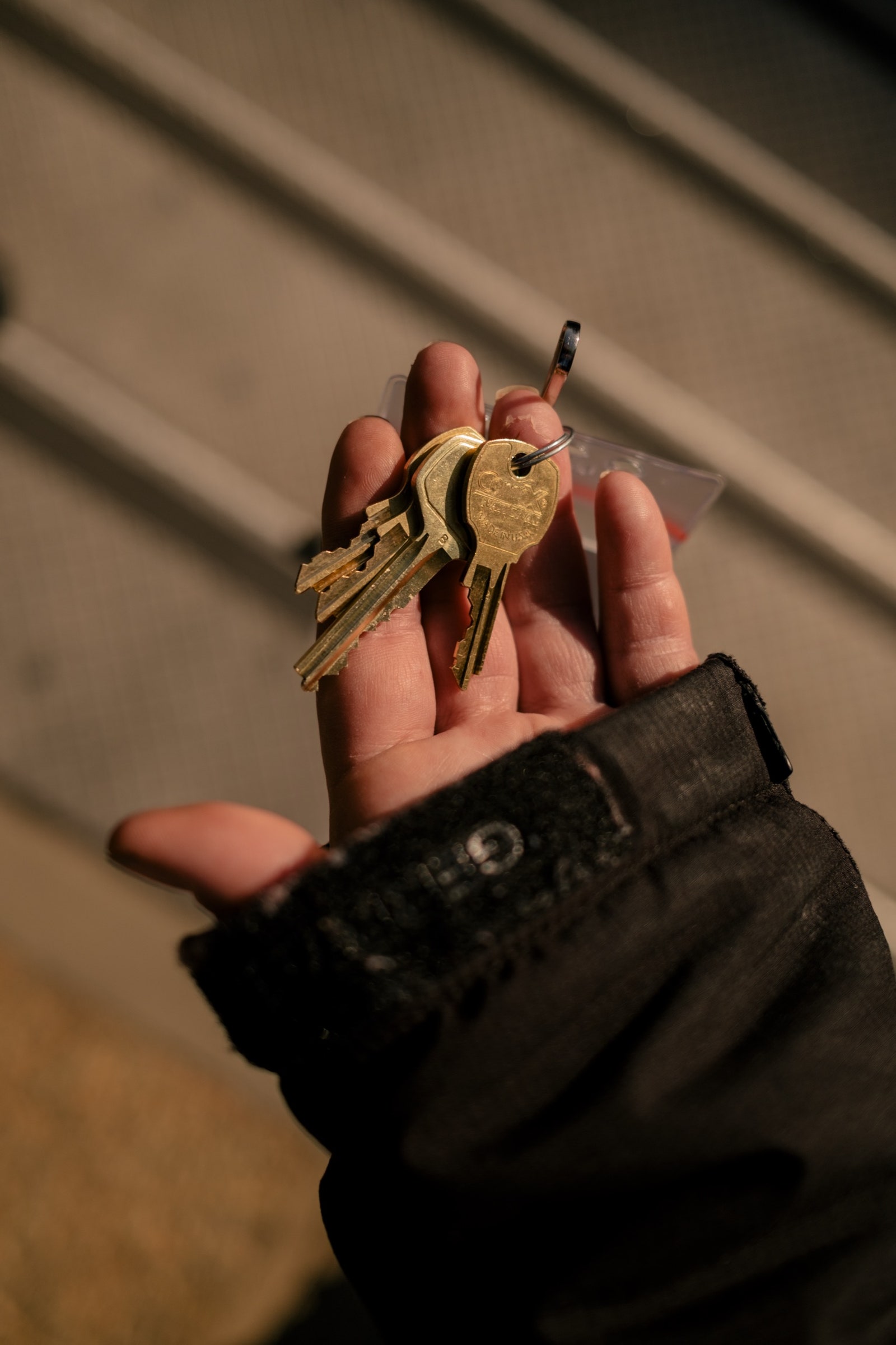 A hand holds out a set of keys.