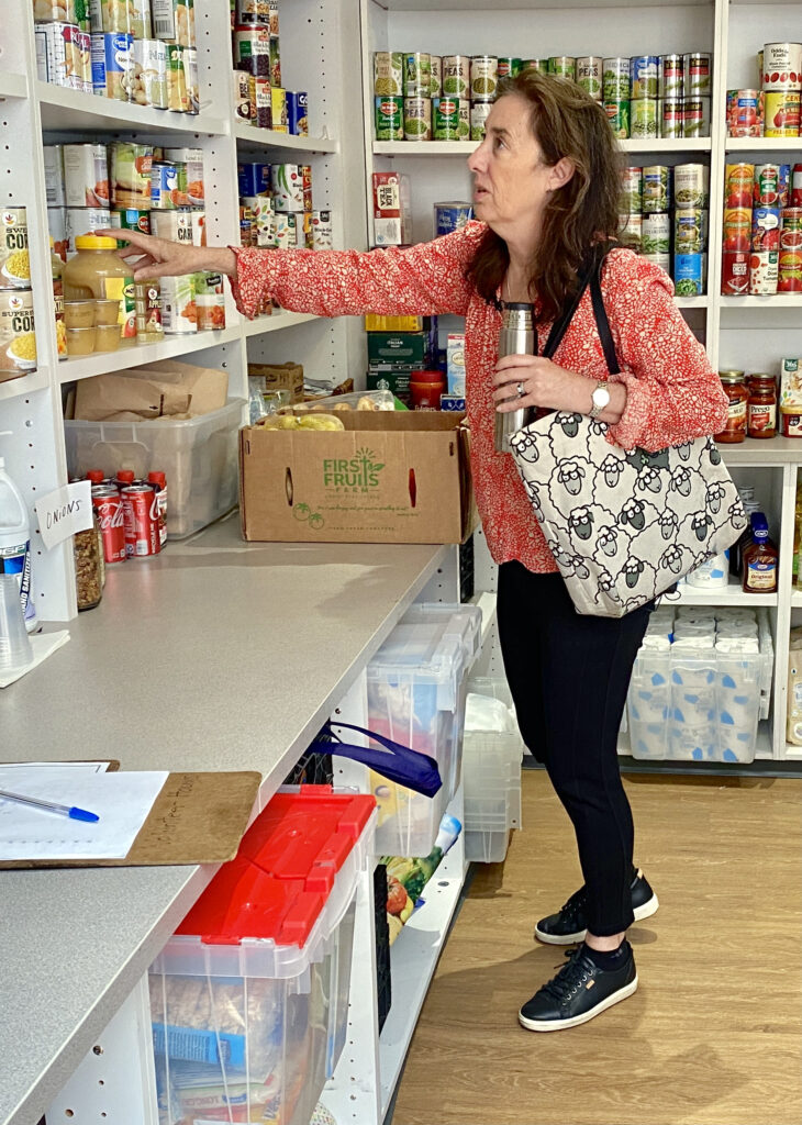 Laurel Peltier scans items at the food pantry at the back of the Cares community office. On Saturdays and Sundays, the nonprofit distributes food items among the needy families who came in for assistance. Credit: Aman Azhar/Inside Climate News