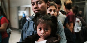 MCALLEN, TX - JUNE 23: A Guatemalan father and his daughter arrives with dozens of other women, men and their children at a bus station following release from Customs and Border Protection on June 23, 2018 in McAllen, Texas. Once families and individuals are released and given a court hearing date they are brought to the Catholic Charities Humanitarian Respite Center to rest, clean up, enjoy a meal and to get guidance to their next destination. Before President Donald Trump signed an executive order Wednesday that halts the practice of separating families who are seeking asylum, over 2,300 immigrant children had been separated from their parents in the zero-tolerance policy for border crossers (Photo by Spencer Platt/Getty Images)