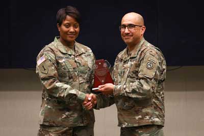Command Sgt. Maj. Lynice D. Thorpe-Noel, the senior enlisted adviser for U.S. Army Human Resources Command, receives an appreciation gift from Sgt. Maj. Roger Rendon, the human resources senior enlisted adviser, U.S. Army Central, during the Women’s History Month observance ceremony on Shaw Air Force Base, South Carolina, in 2019. Thorpe-Noel told a group of Army women that she faced discrimination based on color and gender, but watching other women succeed helped her. Photo by Sgt. Von Marie Donato, courtesy of the U.S. Army. 