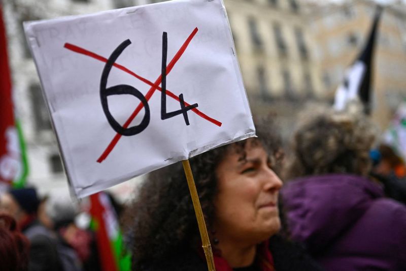 A protester holds a placard with the number 64 crossed out with an X.