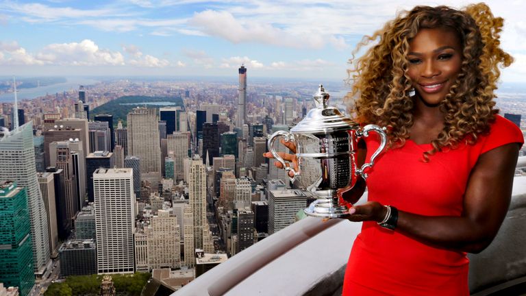 Serena Williams holds the U.S. Open tennis women's singles championship trophy during a visit to the 103rd floor of the Empire State Building, Monday, Sept. 8, 2014, in New York. 
