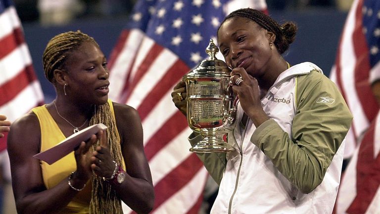 Venus Williams of the US (R) holds the champion's trophy beside her runner-up sister Serena during the women's finals ceremonies at the US Open in Flushing Meadows, New York, 08 September 2001. Venus Williams won the US Open final with a 6-2, 6-4 victory over younger sister Serena in the first Grand Slam final between blacks and the first between sisters in 117 years.