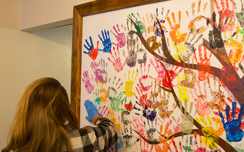 Human trafficking survivors who have branding marks removed put handprints on the Freedom Wall to signify freedom and new beginnings. (Photo by Hunter Fore/Cronkite News)