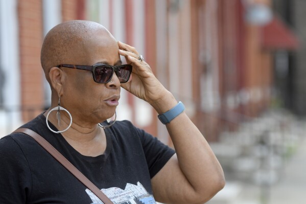 Gloria Webster, of Raleigh, N.C., stands on her old street in Baltimore, on Thursday, June 15, 2023. She lived down the block from St Martin, the Catholic church where her daughter was abused decades ago by their parish priest. Black victims have largely been invisible in the Catholic sexual abuse crisis. Gloria fought hard for justice. The priest was later convicted and defrocked. The family settled with the archdiocese in 1993. (AP Photo/Steve Ruark)