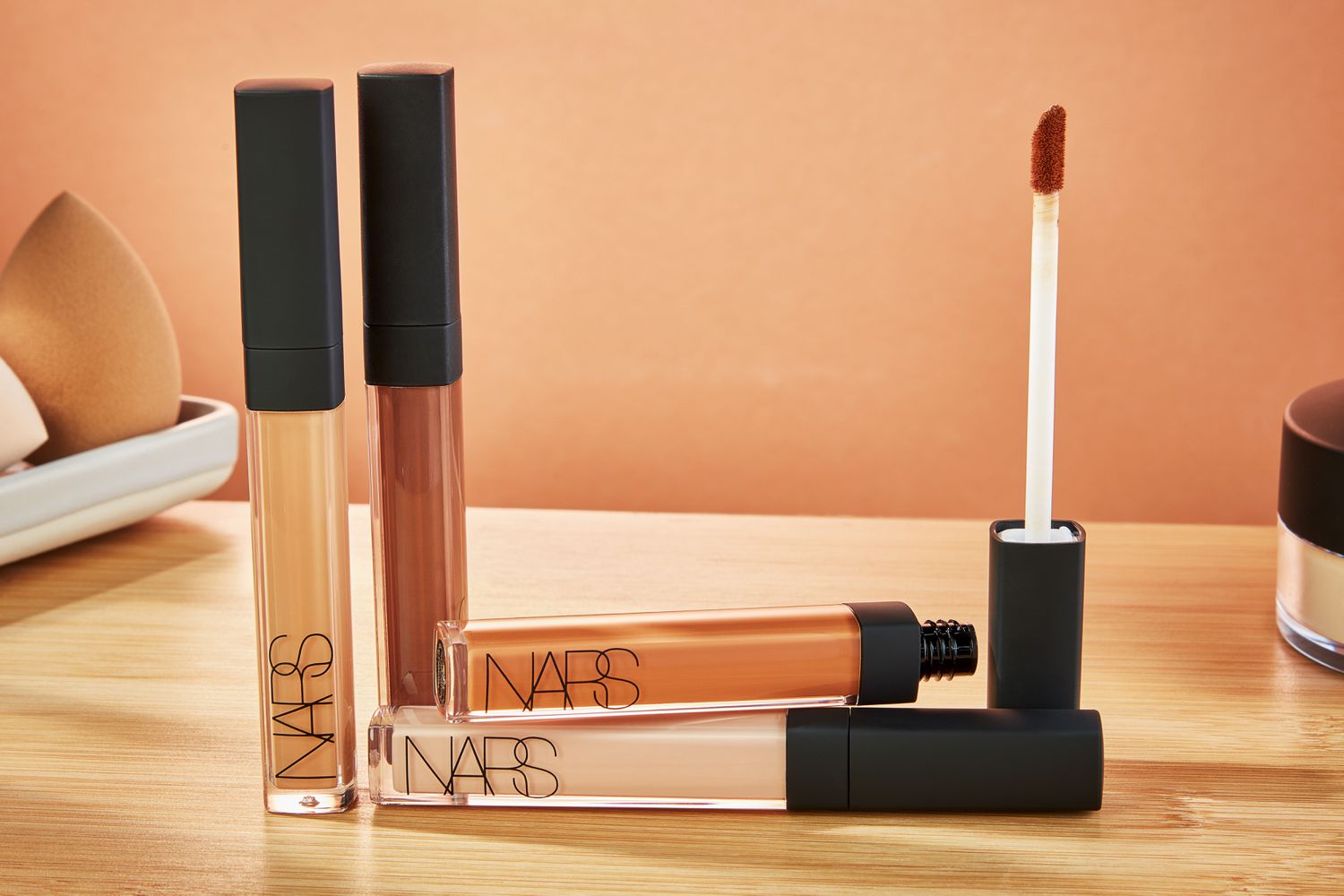 Four tubes of the NARS Radiant Creamy Concealer on a wooden table