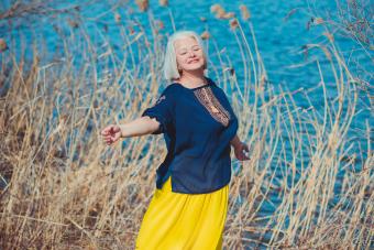 woman in embroidered shirt and yellow skirt at nature, fashionable clothes