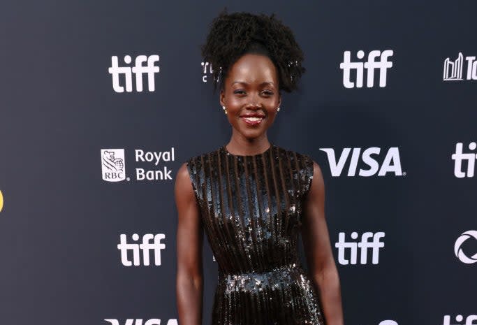 Lupita Nyong'o on the red carpet at TIFF, wearing a sleeveless, floor-length black sequin dress