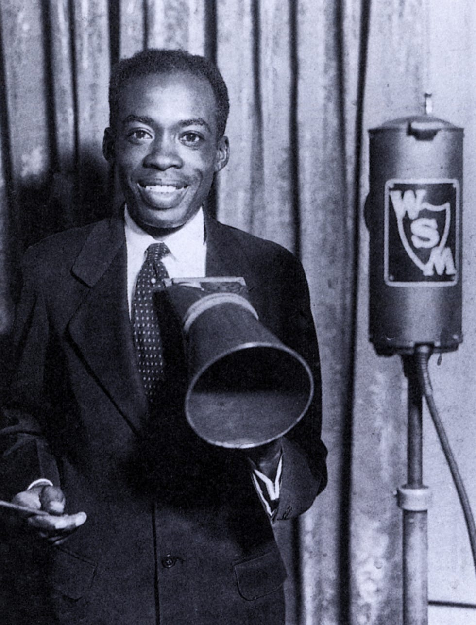 deford bailey smiling and holding a megaphone in a photograph
